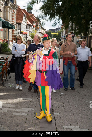 Tourists with man dressed as Pied Piper of Hamelin leading group Germany Stock Photo