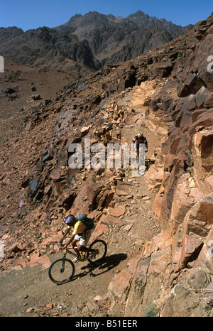 World Champion mountain biker Hans Rey riding with guide at Elijah's Basin, Mt. Sinai, Egypt Stock Photo