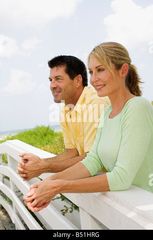 Couple Leaning on Wooden Fence Stock Photo