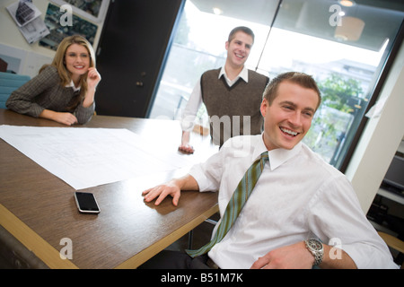 Three Business People Sitting Around Table Stock Photo