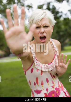 Young Angry Woman Making Hand Gesture in Defence Stock Photo