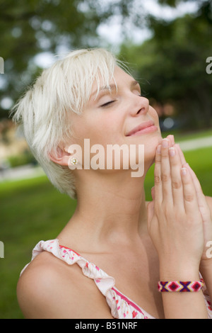 Young Woman Praying Outdoors Stock Photo