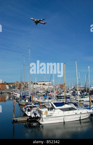 Jumbo jet flying over Ramsgate Royal Marina Kent England Stock Photo