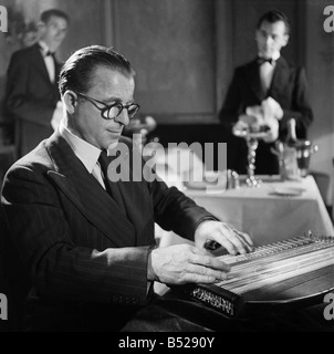 Anton Karas playing the zither at London's Empress Club. Zither played the theme music to the film The Third Man using the instrument. November 1949 ;O20968-001 Stock Photo