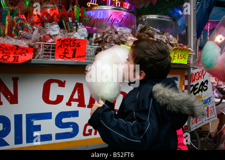 seven year old boy eating candy flow at Nottinghams Goose Fair Stock Photo