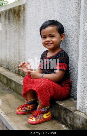 A little girl sitting on the floor Stock Photo