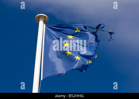 A tattered flag of the European Union waves in the wind Stock Photo