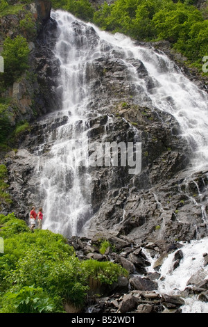 Couple stand and look at  Horsetail Falls in Keystone Canyon near Valdez Alaska Southcentral summer Stock Photo