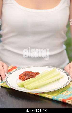 Young Woman Eating Celery and Salsa Model Released Stock Photo