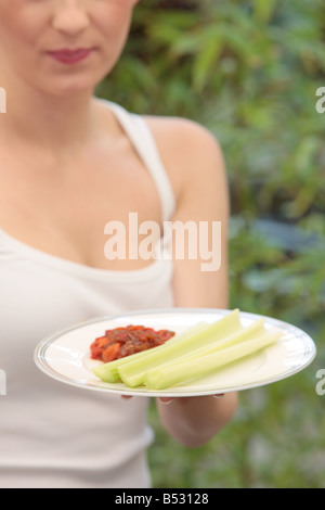 Young Woman Eating Celery and Salsa Model Released Stock Photo