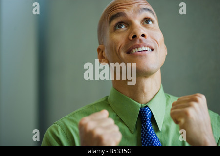 Mixed race businessman smiling with fists clenched Stock Photo