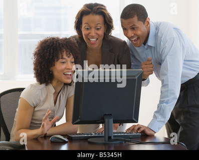 African people looking excited working on computer Stock Photo