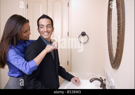 Hispanic woman helping husband with necktie Stock Photo