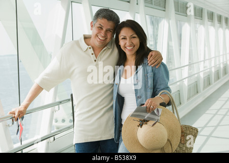 Hispanic couple standing in airport Stock Photo