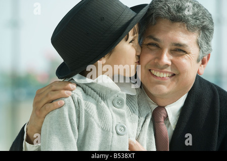 Hispanic girl kissing father’s cheek Stock Photo