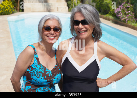 Friends at poolside in bathing suits and sunglasses Stock Photo