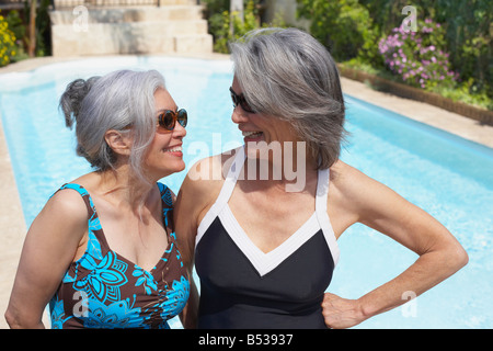 Friends at poolside in bathing suits and sunglasses Stock Photo