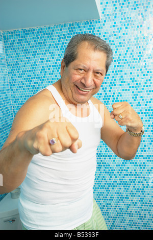 Hispanic man boxing in bathroom Stock Photo