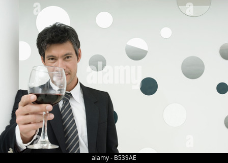 Hispanic businessman drinking wine Stock Photo