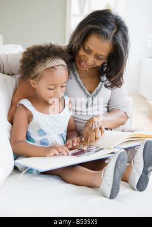 African grandmother looking a photo album with granddaughter Stock Photo