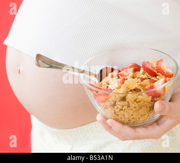 Pregnant Asian woman holding healthy cereal Stock Photo