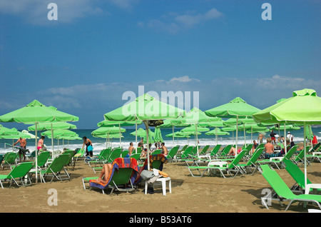 Green sun beds and shade umbrellas on Rethymno beach Crete Greece September 2008 Stock Photo