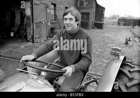 Sport. Football: Sixteen yr old Ronald Aspinwall. He manages Carr Farm. Lathom, near Ormskirk and has been approached by a Chelsea FC coach. Training during his lunch break in the farmyard Ronald Aspinwall practises ball control. Pictured here on his tractor in the yard. December 1969 Z11765 Stock Photo