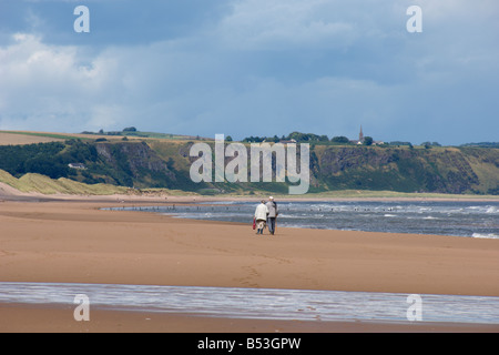 Elderly couple walking along Montrose beach seafront skyscape looking north to St Cyrus Angus coast Scotland August 2008 Stock Photo