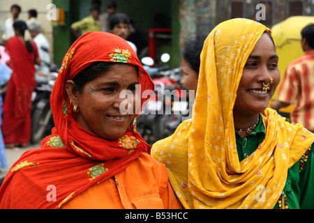 Two tribal women in colourful clothes and wearing head scarves walk on a street in Bangalore, India. Stock Photo