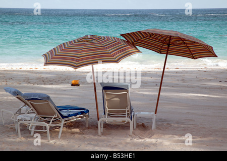 Close-up early evening shot of Beach Umbrellars and sun loungers on a deserted Bermudan beach Stock Photo