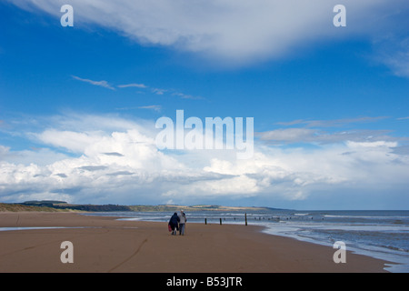 Elderly couple walking along Montrose beach  skyscape looking north to St Cyrus Inverbervie Angus coast Scotland August 2008 Stock Photo