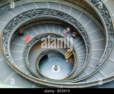 Red tourist rushing down spiral staircase Stock Photo