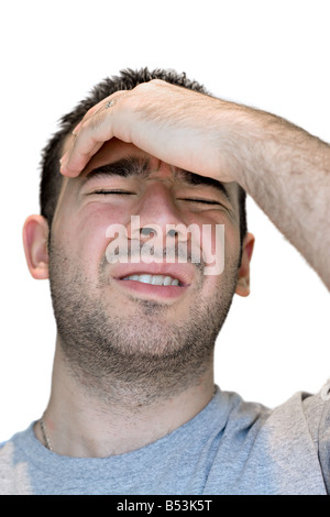 A young man grasps his head in anguish from pain or even stress Stock Photo