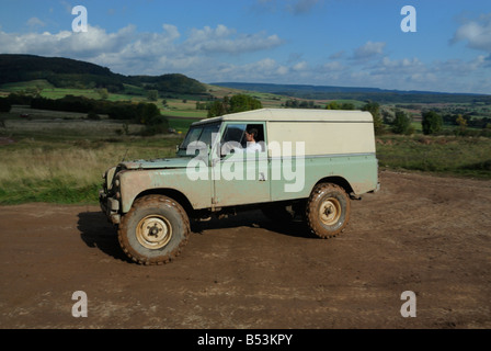 Muddy light green 1970s Land Rover Series 3 LWB Hardtop on a forest track in the Weserbergland. Stock Photo