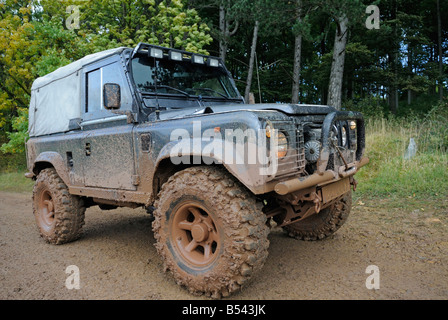 Muddy Land Rover Defender 90 on a forest track in the Weserbergland. Stock Photo