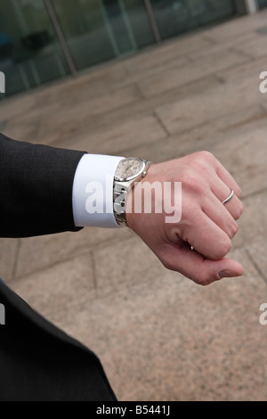 Businessman checking time on watch Stock Photo