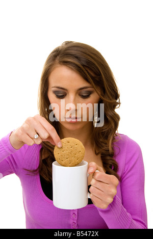 woman dunking biscuit in tea Stock Photo