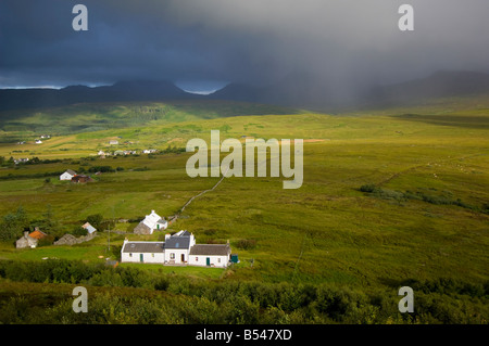 Storm clouds over Ardfernal township looking west towards the Paps of Jura Stock Photo