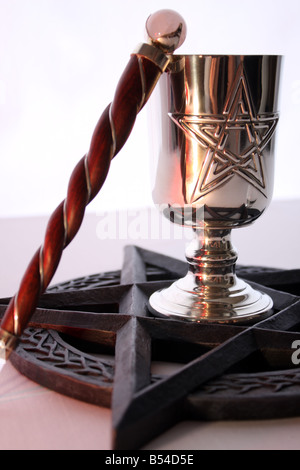 An altar ritual set up on a white background, using a Pentacle, Gemstone Quartz Chalice and Wand. Stock Photo