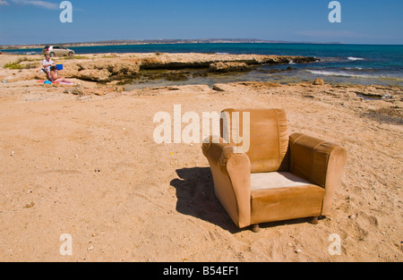 Old easy chair dumped on beach near Ayia Napa on the Mediterranean island of Cyprus EU Stock Photo