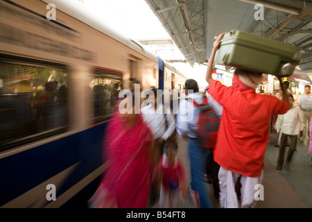 A porter carries bags as the train comes into the station, India Sawai Madhopur station, Rajasthan, India Stock Photo