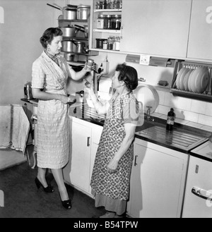 Women: Tall: Mrs. Helen Gavin President of The Tall Women's Association seen here around the house and kitchen. September 1953 Stock Photo