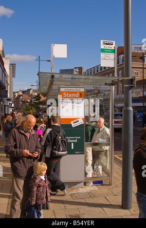 People waiting in city centre of Norwich,Norfolk,Uk to catch a bus at the bus stop Stock Photo