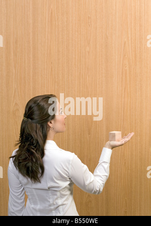 woman holds wooden cube Stock Photo