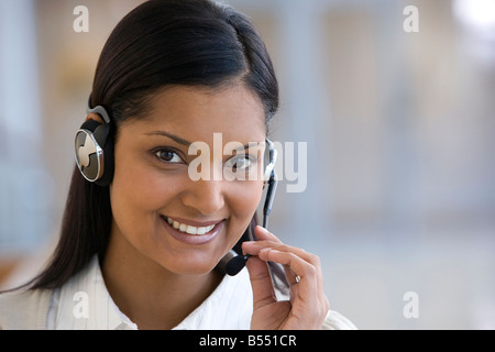 A smiling businesswoman speaking on her headset Stock Photo