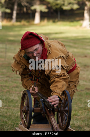 Man wearing trapper costume demonstrating black powder cannon at Steam Engine Show at Westwold, 'British Columbia', Canada Stock Photo