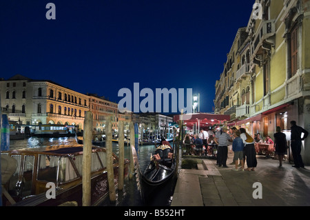 Restaurant and Gondolas at night on the Grand Canal near to the Rialto Bridge, Venice, Veneto, Italy Stock Photo
