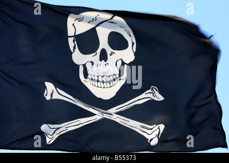 black pirate flag fluttering in the wind parts of it blurry due to strong wind Stock Photo