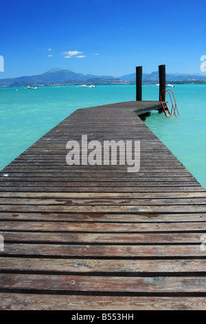 a small jetty in lake Garda Italy fantastic color in the water and sky Perfect for concepts of vacation or holidays Stock Photo