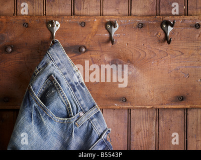 Blue Jeans Hanging On Hook Weathered Wood Wall Stock Photo